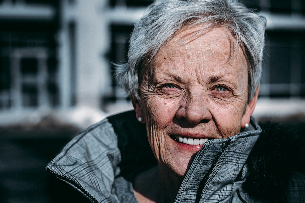 Smiling older woman with short grey hair, outdoors
